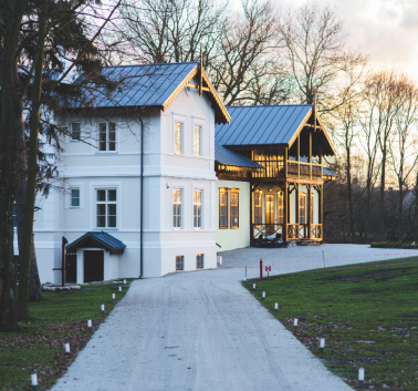 A picturesque white house topped with a blue roof, exuding a sense of tranquility and classic architectural beauty.